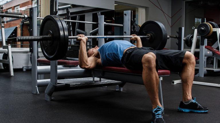 Close up of hands gripping handles on chest press equipment
