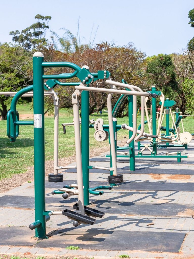 Kids and adults using solar powered outdoor gym machines