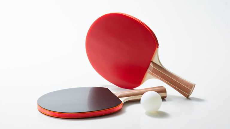 Professional table tennis match in progress on an indoor court