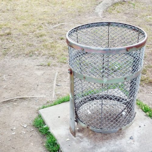 Round steel dustbin with lid placed in a modern kitchen corner