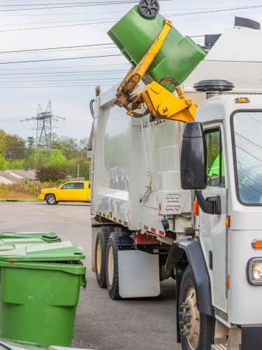 Side view of Triveni Solar garbage truck on city streets