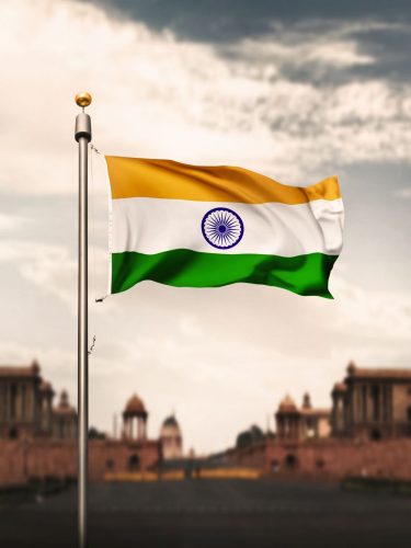 Tall flag mast pole with national flag against a blue sky
