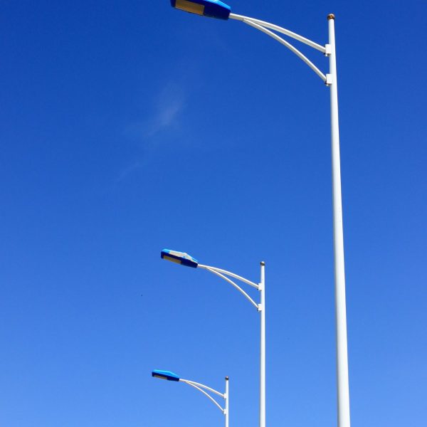 Tall street light poles lining a residential street at night